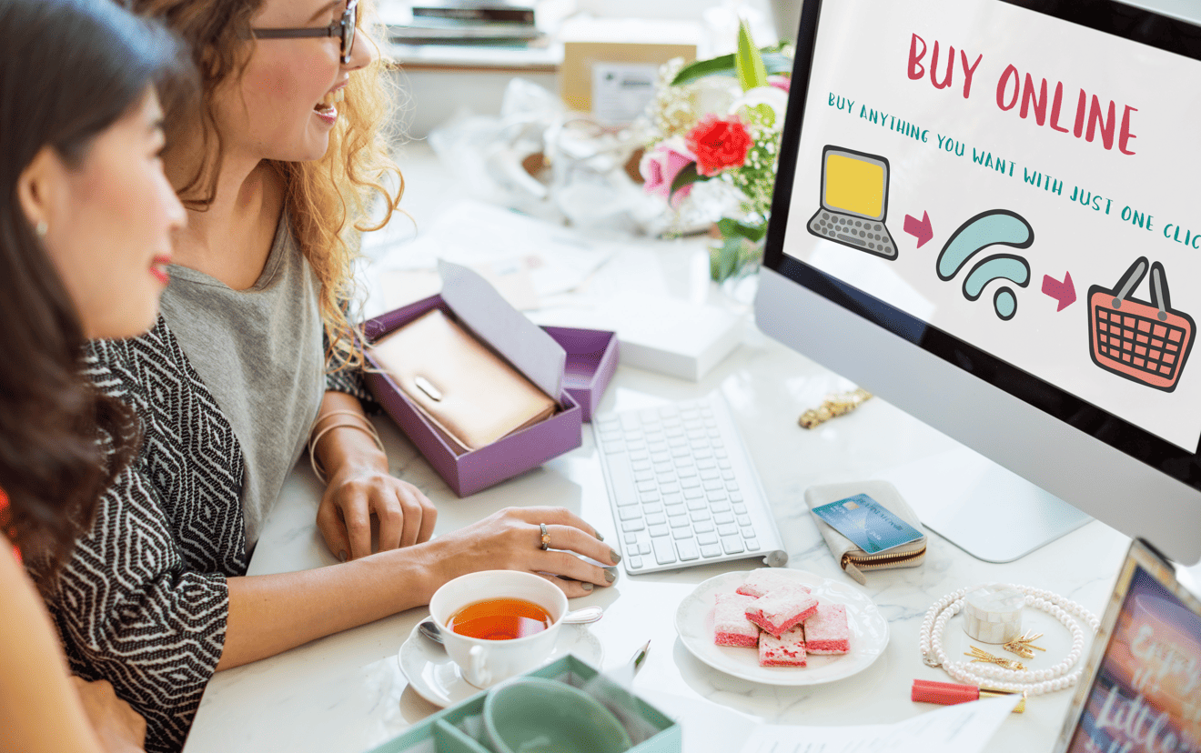 Two women working at a desk looking at an e-commerce screen, illustrating multilingual content marketing localization in SEA.