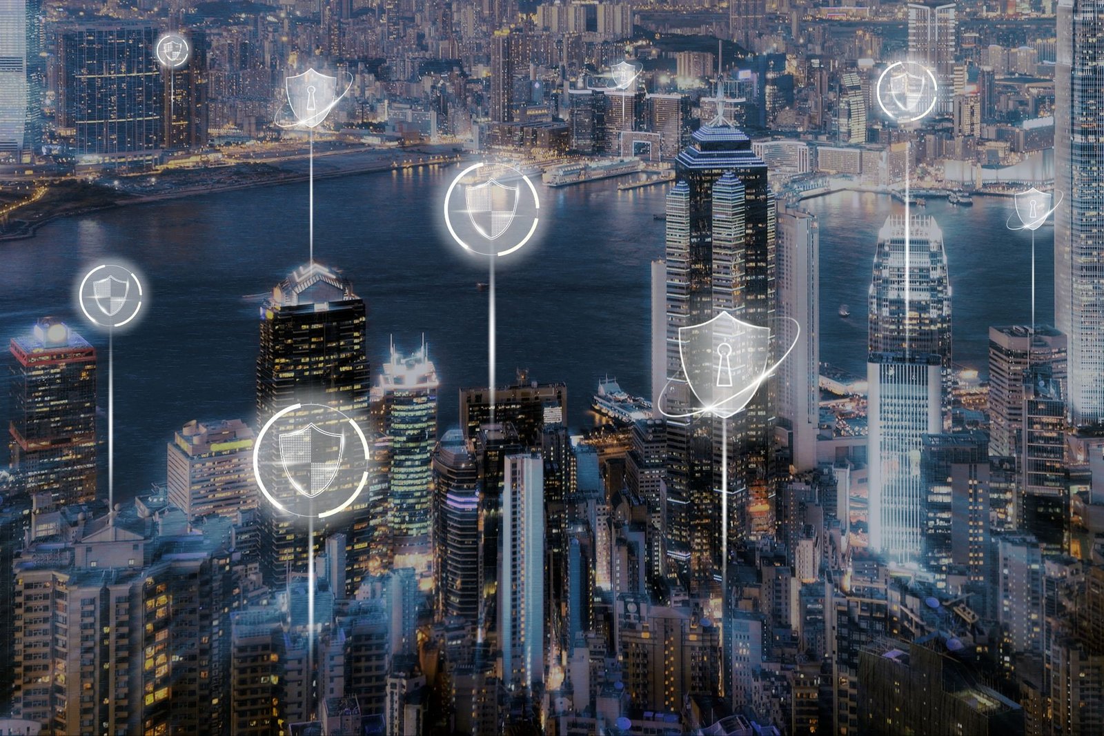 Futuristic city skyline at night with glowing digital shield icons over skyscrapers, symbolizing intellectual property protection and cybersecurity in global patent translation