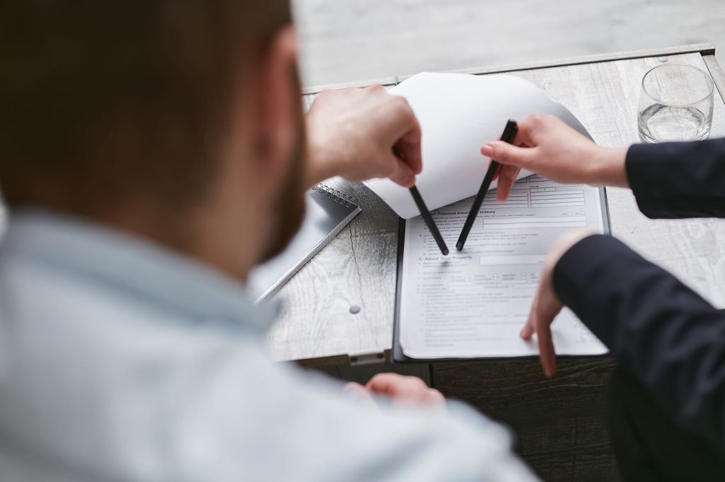 Colleagues analyze technical documents to ensure shared terms are consistent in owner's and service manual translations.